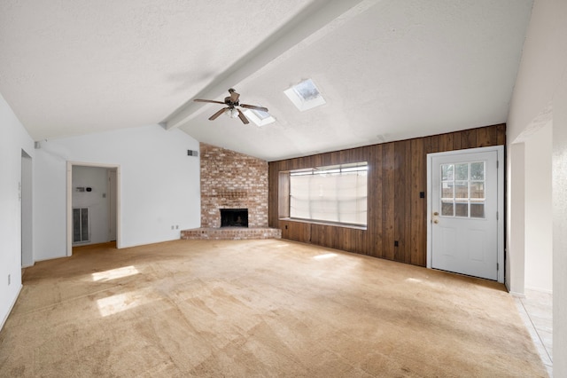 1639 Castle Creek Dr, Missouri City, TX 77489 - unfurnished living room with a ceiling fan, a fireplace, carpet, wooden walls, and a skylight