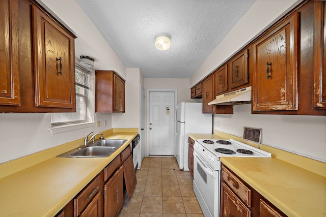 1639 Castle Creek Dr, Missouri City, TX 77489 - kitchen with under cabinet range hood, white appliances, a sink, a textured ceiling, and light countertops