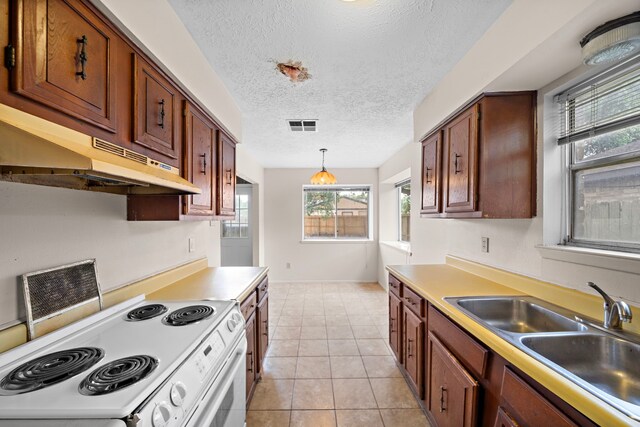 1639 Castle Creek Dr, Missouri City, TX 77489 - kitchen featuring white electric range, under cabinet range hood, a sink, hanging light fixtures, and light countertops