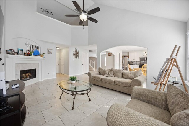 10123 Twila Springs Ct, Houston, TX 77095 - living room with arched walkways, high vaulted ceiling, stairs, a ceiling fan, and a tile fireplace