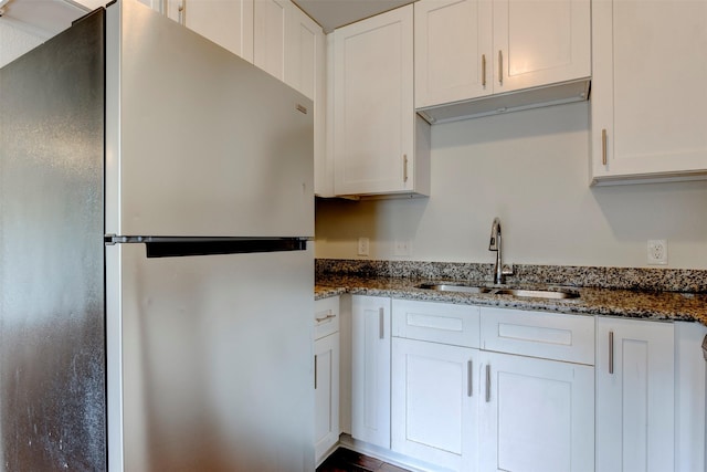 9022 Sultan Dr, Houston, TX 77078 - kitchen with freestanding refrigerator, a sink, white cabinets, and dark stone countertops