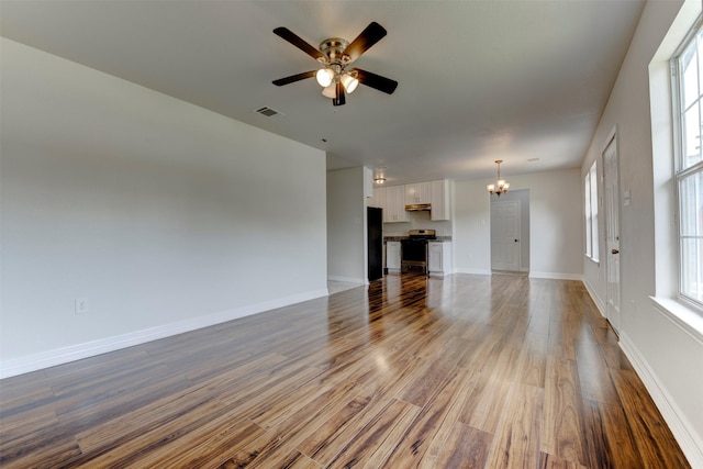 9022 Sultan Dr, Houston, TX 77078 - unfurnished living room featuring a chandelier, wood finished floors, a ceiling fan, and baseboards