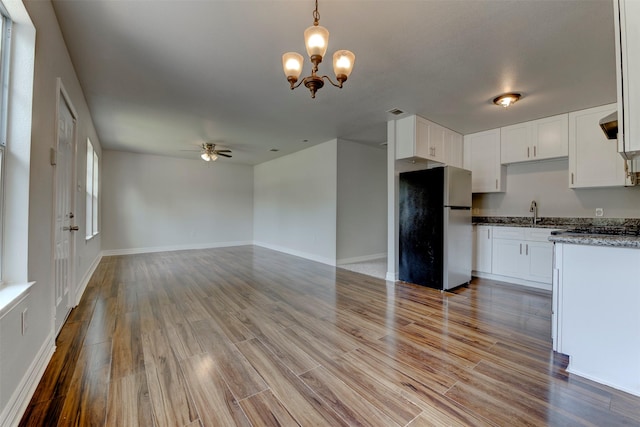 9022 Sultan Dr, Houston, TX 77078 - kitchen with appliances with stainless steel finishes, a chandelier, white cabinetry, wood finished floors, and decorative light fixtures