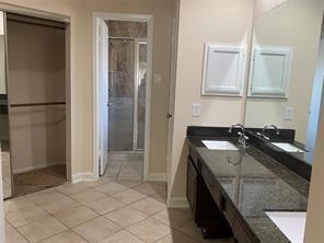 2214 S Ferrisburg Ct, Sugar Land, TX 77478 - full bath with double vanity, tile patterned flooring, baseboards, and an enclosed shower