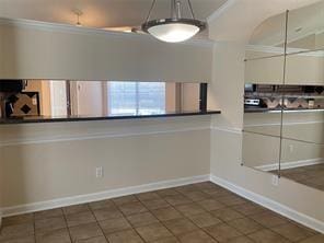 2214 S Ferrisburg Ct, Sugar Land, TX 77478 - unfurnished dining area featuring dark tile patterned floors, crown molding, and baseboards