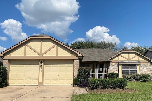 2214 S Ferrisburg Ct, Sugar Land, TX 77478 - tudor-style house with stucco siding, concrete driveway, an attached garage, brick siding, and roof with shingles