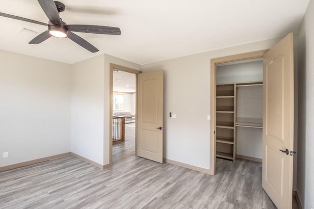 103 Whispering Oaks, Somerville, TX 77879 - unfurnished bedroom featuring light wood-type flooring, baseboards, ceiling fan, a closet, and a walk in closet