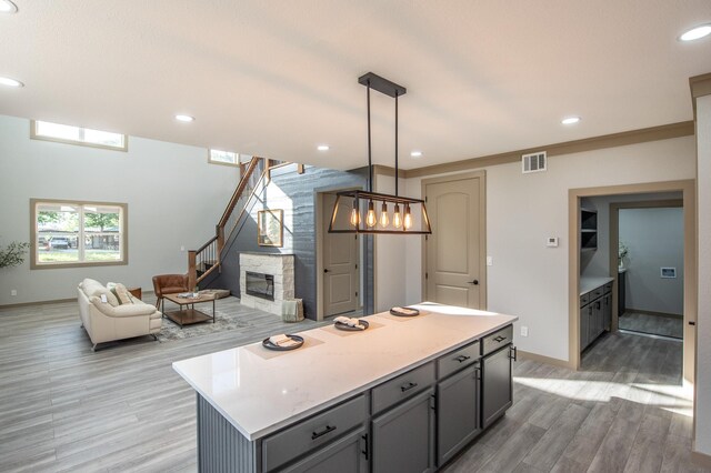 103 Whispering Oaks, Somerville, TX 77879 - kitchen featuring light wood-type flooring, a kitchen island, light countertops, gray cabinetry, and open floor plan
