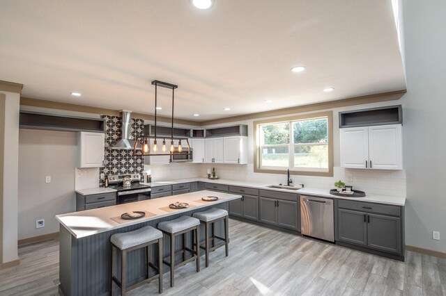 103 Whispering Oaks, Somerville, TX 77879 - kitchen featuring wall chimney exhaust hood, stainless steel appliances, gray cabinetry, a sink, and backsplash