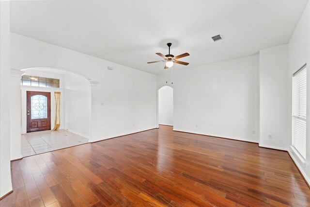 3303 Hickory Knoll Dr, Pearland, TX 77581 - unfurnished living room featuring arched walkways, a ceiling fan, hardwood / wood-style flooring, ornate columns, and baseboards