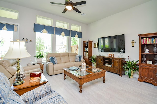 18234 Shoreline Vista Ln, Cypress, TX 77433 - living room with ceiling fan, light wood finished floors, a towering ceiling, and baseboards