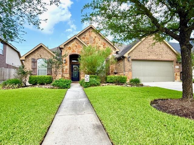 1216 Matthew Hills Ln, Spring, TX 77386 - view of front of property featuring brick siding, an attached garage, concrete driveway, and stone siding