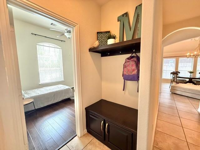 1216 Matthew Hills Ln, Spring, TX 77386 - mudroom with light tile patterned flooring, plenty of natural light, a chandelier, and arched walkways