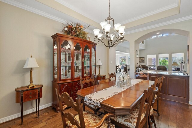 5131 Rowley Falls Ln, Sugar Land, TX 77479 - dining room featuring arched walkways, dark wood-type flooring, a chandelier, crown molding, and baseboards