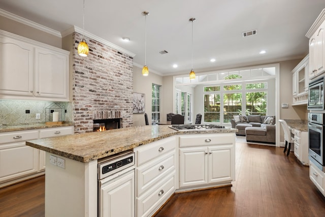 12126 Oak Park Dr, Houston, TX 77070 - kitchen featuring open floor plan, a brick fireplace, backsplash, stainless steel appliances, and crown molding