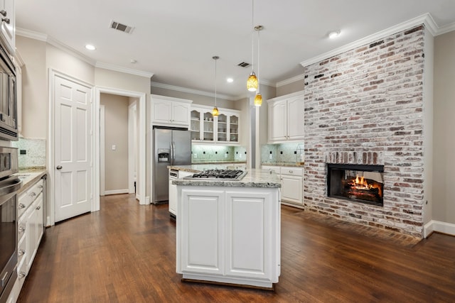 12126 Oak Park Dr, Houston, TX 77070 - kitchen with appliances with stainless steel finishes, white cabinetry, dark wood finished floors, tasteful backsplash, and recessed lighting