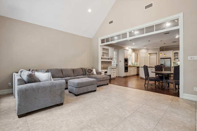 12126 Oak Park Dr, Houston, TX 77070 - living area with high vaulted ceiling, light tile patterned flooring, baseboards, and recessed lighting