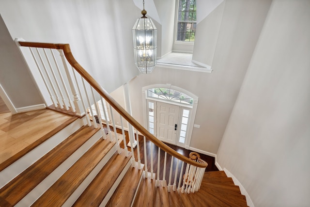 12126 Oak Park Dr, Houston, TX 77070 - staircase featuring a towering ceiling, a chandelier, wood finished floors, and baseboards