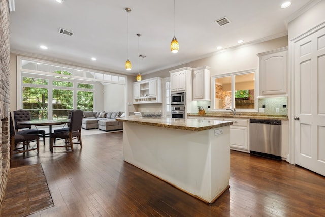 12126 Oak Park Dr, Houston, TX 77070 - kitchen with appliances with stainless steel finishes, crown molding, plenty of natural light, backsplash, and light stone countertops