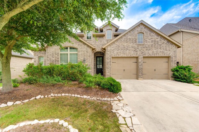 28418 Asher Falls Ln, Fulshear, TX 77441 - french provincial home with brick siding, concrete driveway, and an attached garage