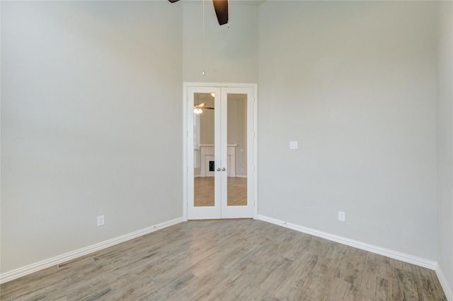 28418 Asher Falls Ln, Fulshear, TX 77441 - unfurnished room featuring ceiling fan, light wood-type flooring, french doors, baseboards, and a towering ceiling