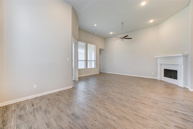 28418 Asher Falls Ln, Fulshear, TX 77441 - unfurnished living room with a ceiling fan, a fireplace, light wood-style flooring, recessed lighting, and baseboards