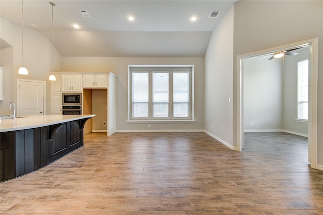 28418 Asher Falls Ln, Fulshear, TX 77441 - kitchen with built in microwave, lofted ceiling, stainless steel oven, a sink, and light countertops