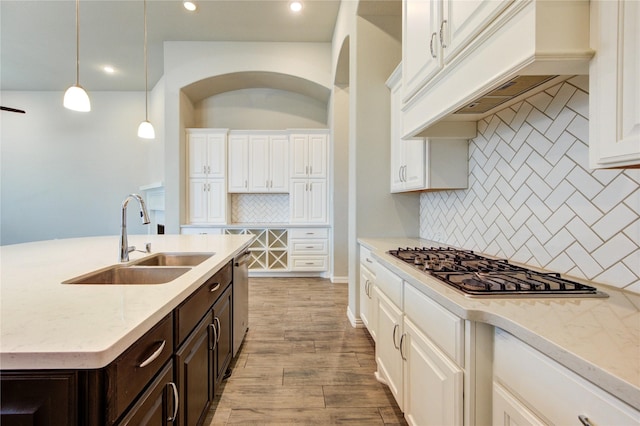 28418 Asher Falls Ln, Fulshear, TX 77441 - kitchen with a sink, white cabinets, appliances with stainless steel finishes, dark brown cabinets, and tasteful backsplash