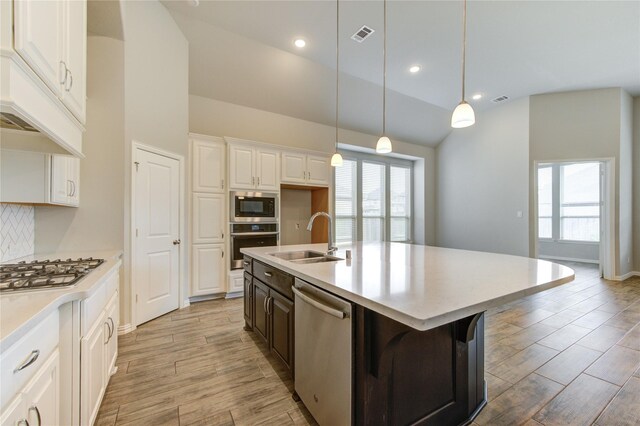 28418 Asher Falls Ln, Fulshear, TX 77441 - kitchen with appliances with stainless steel finishes, a sink, light wood finished floors, tasteful backsplash, and light countertops