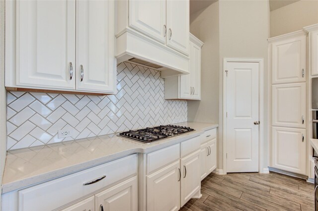 28418 Asher Falls Ln, Fulshear, TX 77441 - kitchen featuring stainless steel gas cooktop, white cabinetry, and decorative backsplash