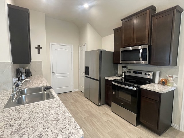 17768 Lionheart Rd, Conroe, TX 77306 - kitchen with stainless steel appliances, a sink, decorative backsplash, dark brown cabinets, and vaulted ceiling