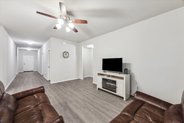 643 E Fairway Lake Dr, Alvin, TX 77511 - living area featuring a ceiling fan, light wood-style flooring, and baseboards