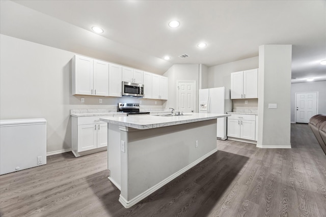 643 E Fairway Lake Dr, Alvin, TX 77511 - kitchen with stainless steel appliances, light countertops, light wood-type flooring, white cabinetry, and recessed lighting