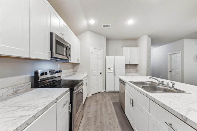 643 E Fairway Lake Dr, Alvin, TX 77511 - kitchen with stainless steel appliances, a sink, white cabinetry, light wood-style flooring, and recessed lighting