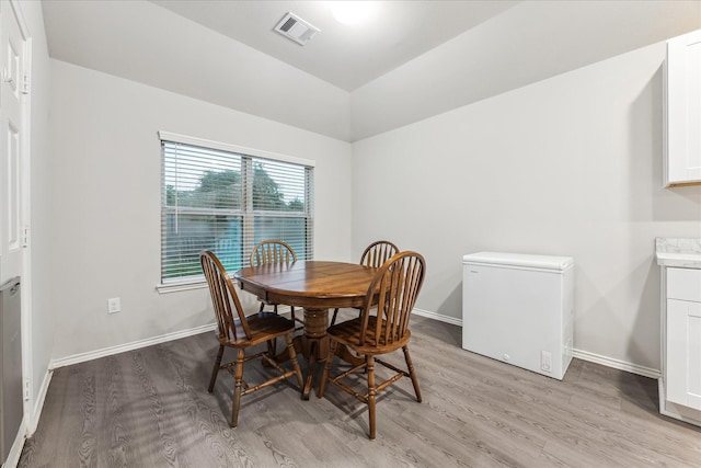 643 E Fairway Lake Dr, Alvin, TX 77511 - dining space with light wood-style floors, baseboards, and vaulted ceiling