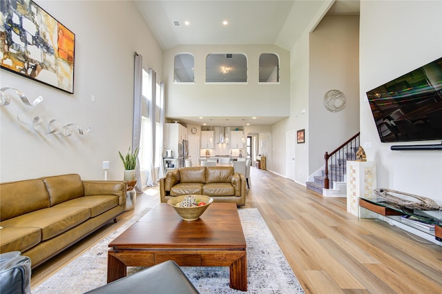 11702 Twin Creeks Hill Dr, Cypress, TX 77433 - living area featuring high vaulted ceiling, light wood-type flooring, stairway, recessed lighting, and baseboards