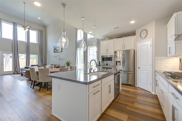 11702 Twin Creeks Hill Dr, Cypress, TX 77433 - kitchen with stainless steel appliances, a sink, wood finished floors, tasteful backsplash, and a center island with sink