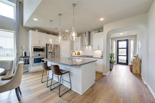 11702 Twin Creeks Hill Dr, Cypress, TX 77433 - kitchen featuring wall chimney exhaust hood, stainless steel appliances, a sink, a kitchen bar, and backsplash