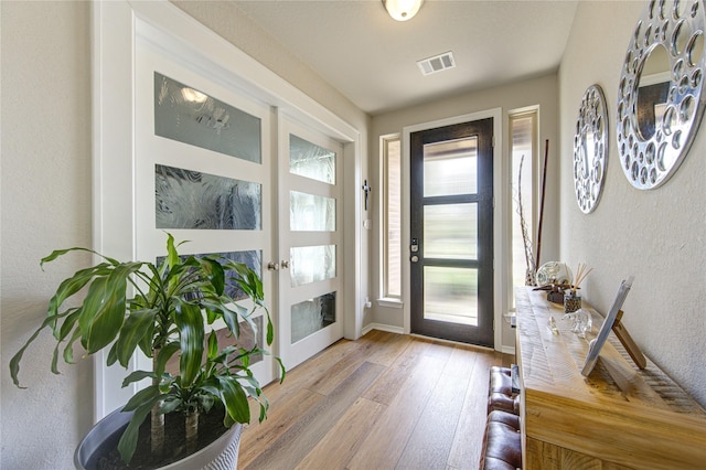 11702 Twin Creeks Hill Dr, Cypress, TX 77433 - foyer featuring light wood finished floors, a textured wall, and baseboards