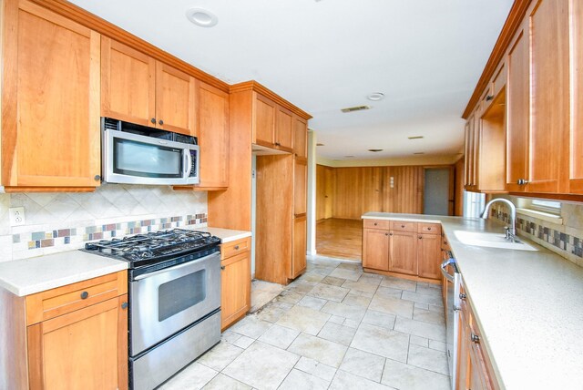 4721 Briarbend Dr, Houston, TX 77035 - kitchen featuring appliances with stainless steel finishes, decorative backsplash, a sink, light countertops, and light stone finish floors