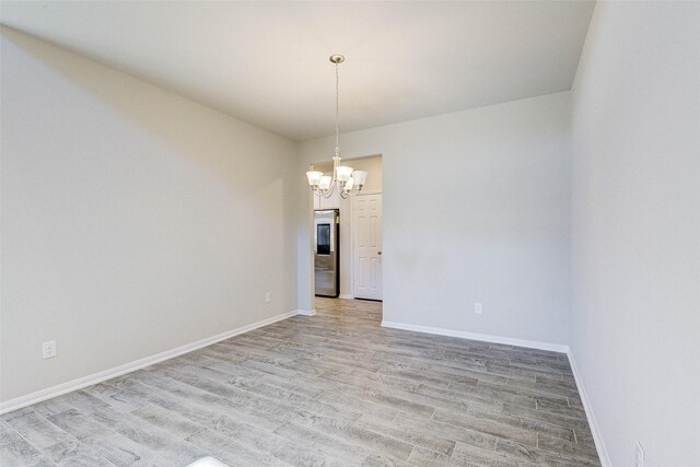 21430 Costalinda Dr, Cypress, TX 77433 - spare room featuring a chandelier, light wood-style floors, and baseboards