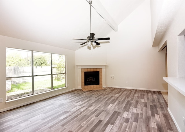 194 Moonridge Dr, Houston, TX 77015 - unfurnished living room featuring light wood-style flooring, high vaulted ceiling, ceiling fan, a fireplace, and baseboards