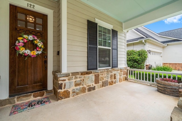 122 Cherry Oak Ln, Montgomery, TX 77316 - view of exterior entry featuring a porch, stone siding, and an attached garage