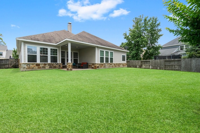 122 Cherry Oak Ln, Montgomery, TX 77316 - rear view of house featuring stone siding, a patio area, a chimney, and roof with shingles