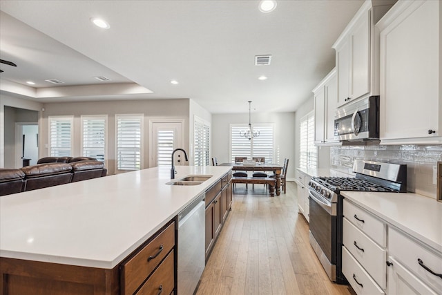 538 Still Water Ridge Ln, Sealy, TX 77474 - kitchen featuring stainless steel appliances, a sink, light countertops, white cabinetry, and recessed lighting