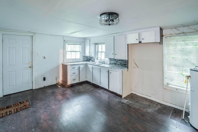 7988 Joy St, Houston, TX 77028 - kitchen with a sink, light countertops, white cabinets, dark wood-style flooring, and water heater