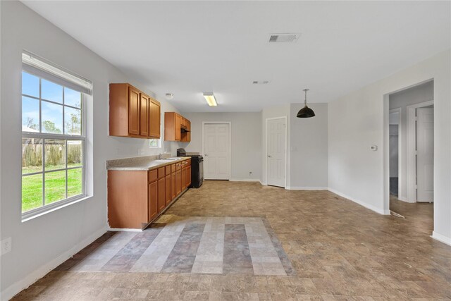 424 Baker Cir, Ames, TX 77575 - kitchen with black stove, light countertops, brown cabinets, baseboards, and a sink