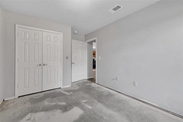424 Baker Cir, Ames, TX 77575 - unfurnished bedroom featuring a closet and concrete floors