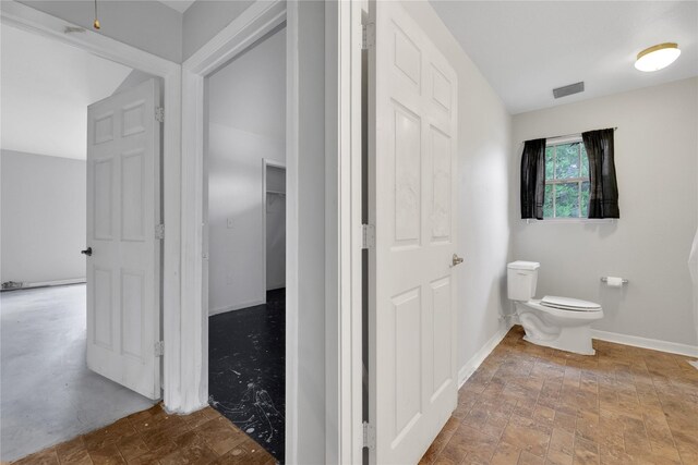 424 Baker Cir, Ames, TX 77575 - bathroom featuring toilet, stone finish floors, and baseboards