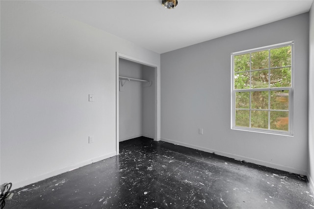 424 Baker Cir, Ames, TX 77575 - unfurnished bedroom featuring baseboards, a closet, and concrete flooring